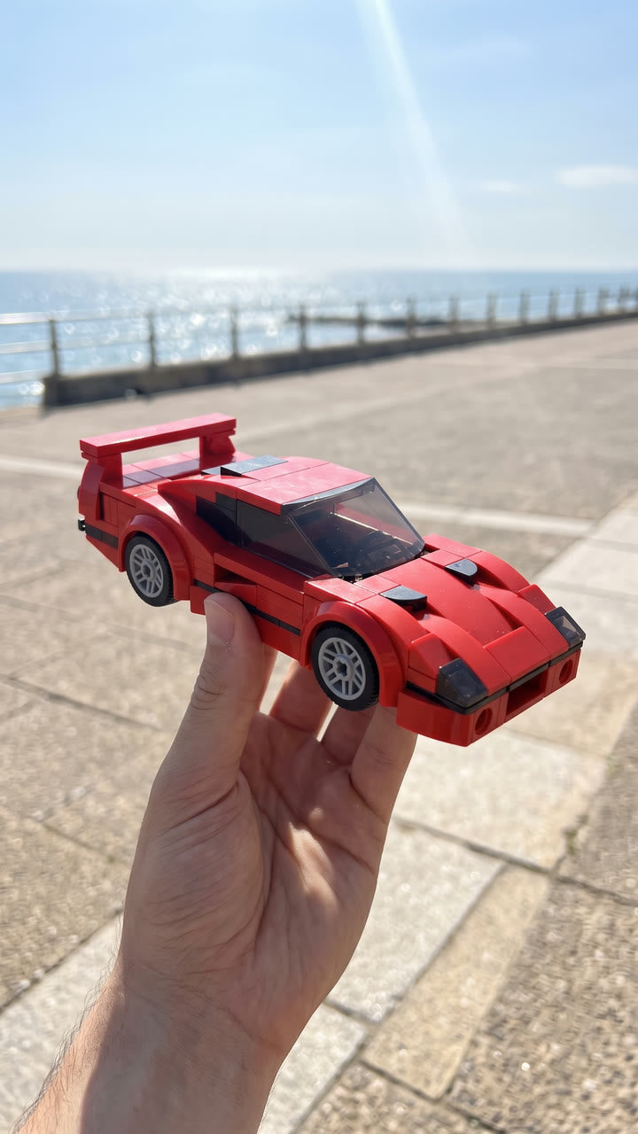A red brick-built supercar held up on a seaside promenade
