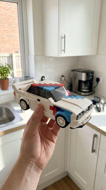A white brick-built touring car with racing stripes held up in a bright kitchen