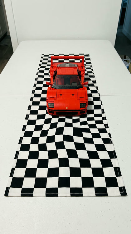 A red brick-built supercar on a checkered race flag