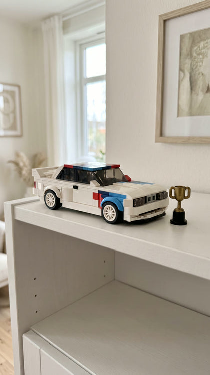 A white brick-built touring car on a shelf next to a small trophy