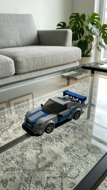 A silver and blue brick-built sports car on a glass coffee table